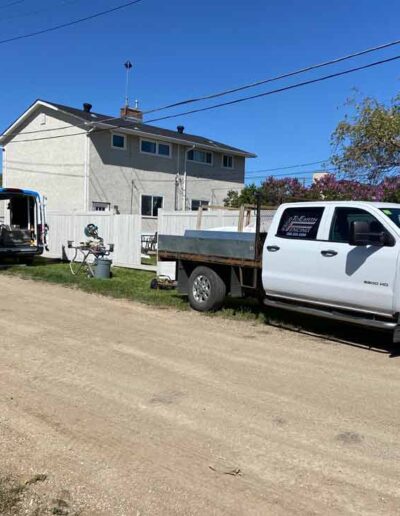 Professional Vinyl Fence Installation in Regina. Truck, van, and tools at job site